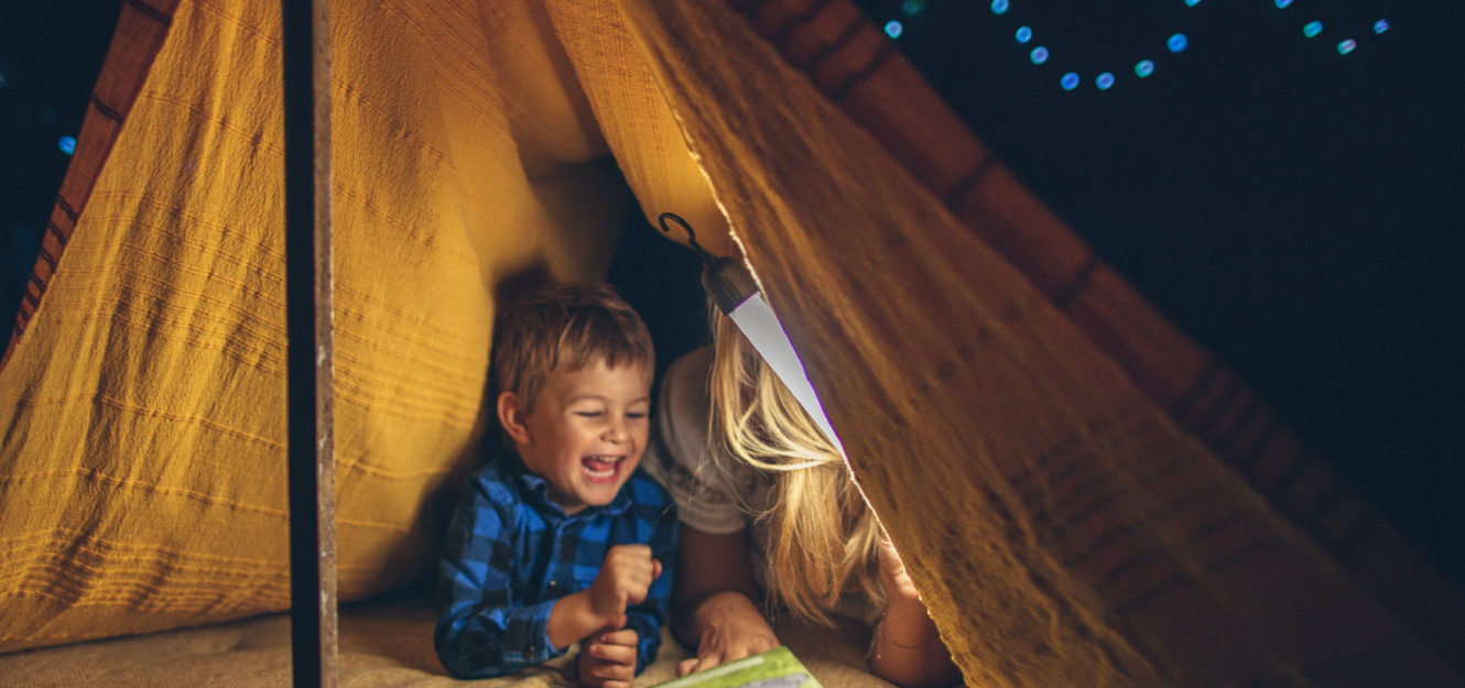 a little boy playing in a tent